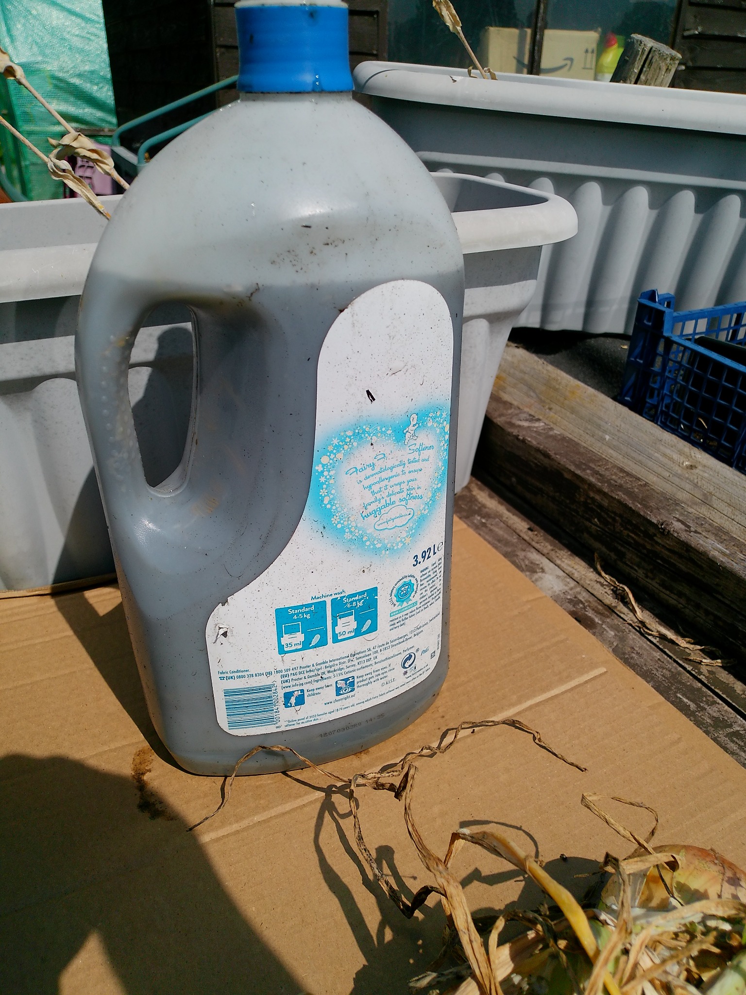 A reused container holding homemade liquid fertiliser