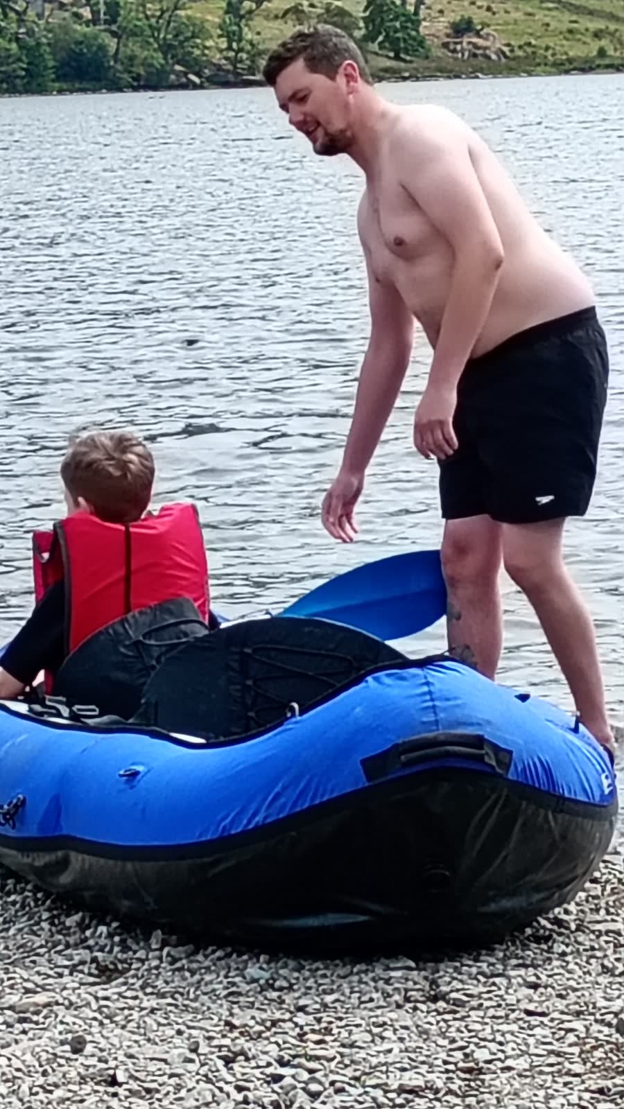 Dave's son helping his grandson into an inflatable canoe at Ullswater