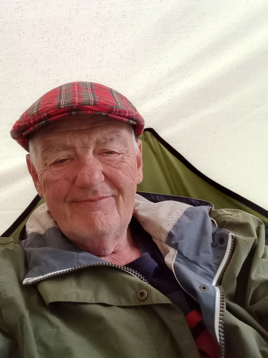 Dave smiling beneath the rain-covered shelter on the final morning