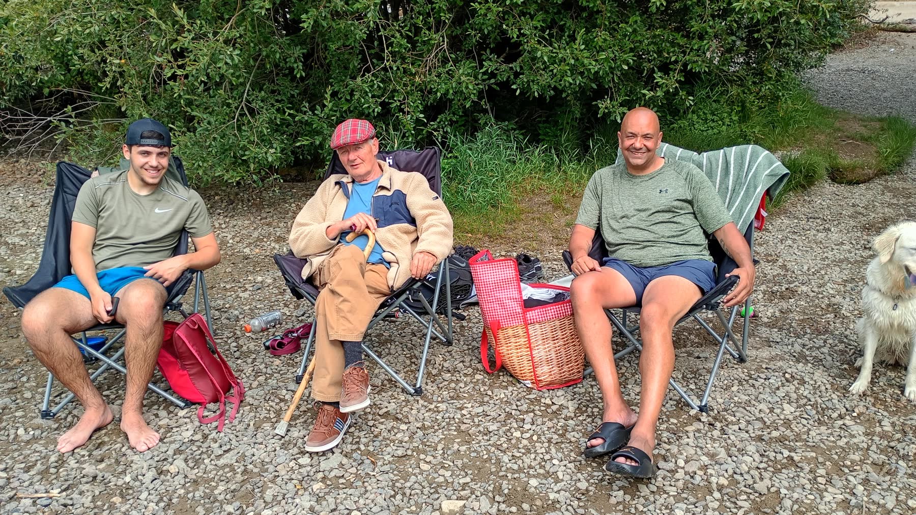 Dave sitting beside his grandson and son-in-law with a picnic basket at Ullswater
