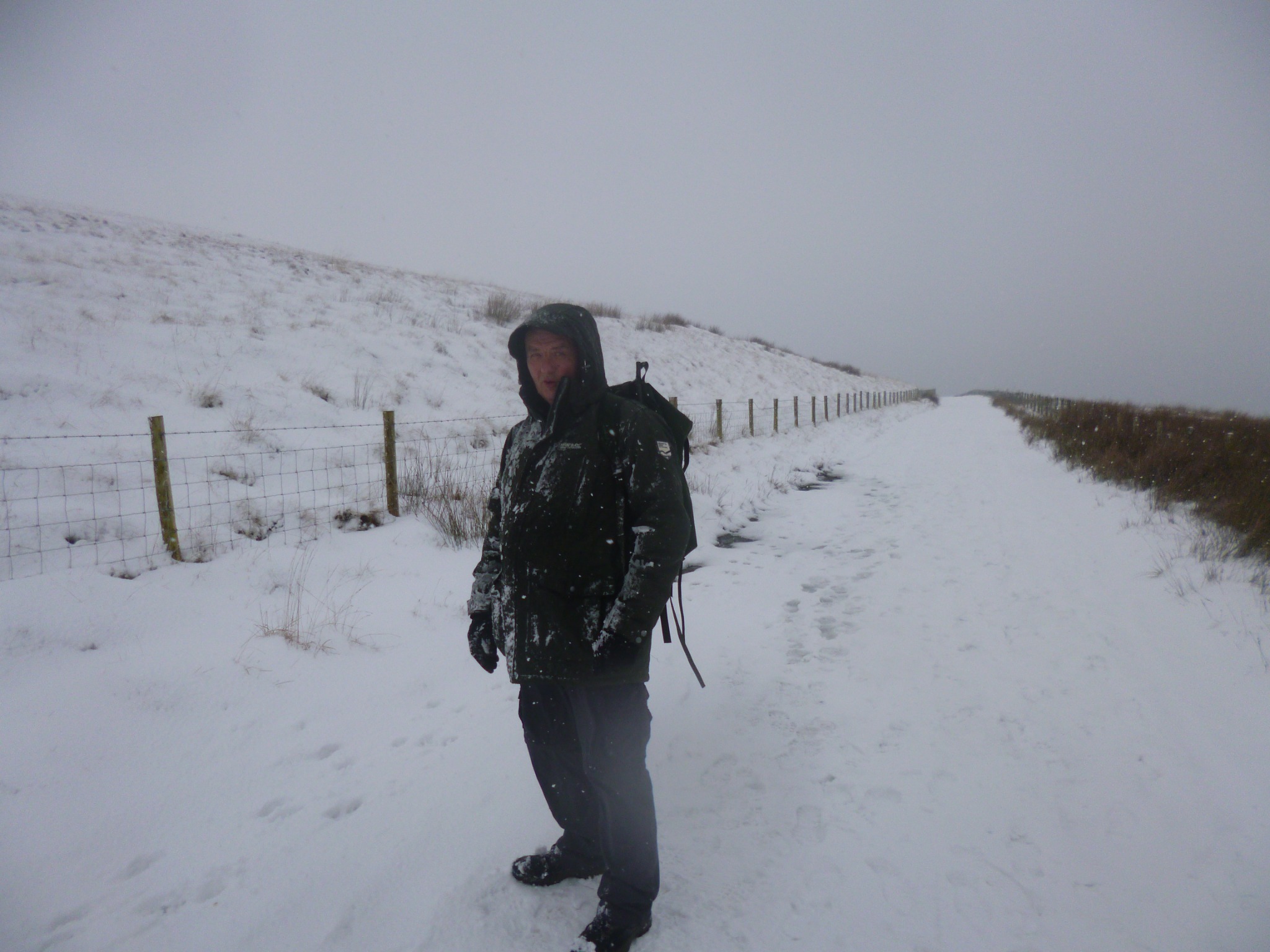 Dave standing on a deeply snow-covered track during a winter walk